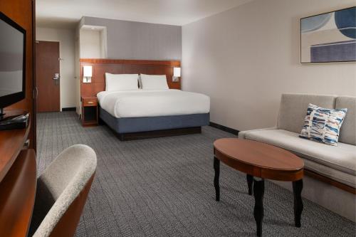 a hotel room with a bed and a couch at Courtyard by Marriott Ontario Rancho Cucamonga in Rancho Cucamonga