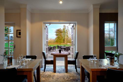 a restaurant with tables and chairs and a large window at Delta Hotels by Marriott St Pierre Country Club in Chepstow