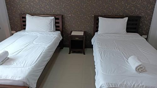 two beds sitting next to each other in a room at Norrarat Place นรรัตน์ เพลส in Chiang Rai