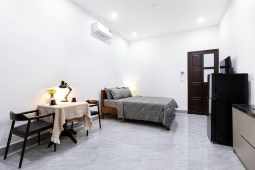 ein Wohnzimmer mit einem Bett und einem Tisch und einem Bett sowie ein Zimmer mit in der Unterkunft Apartment 152 LVH in Đà Nẵng