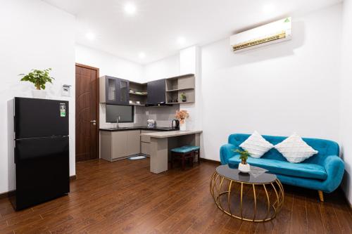 ein Wohnzimmer mit einem blauen Sofa und einer Küche in der Unterkunft Apartment 152 LVH in Đà Nẵng