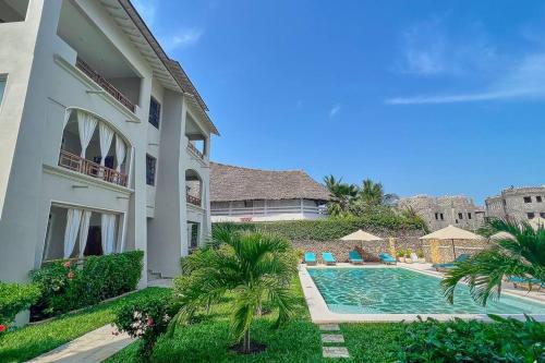 a house with a swimming pool next to a building at Beach Apartment 4 Passi Residence in Watamu