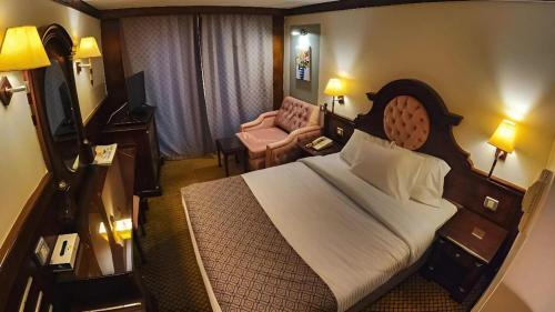 a bedroom with a large bed in a hotel room at Nile CRUISE NPS Every Monday from Luxor 4 nights & every Friday from Aswan 3 nights in Aswan