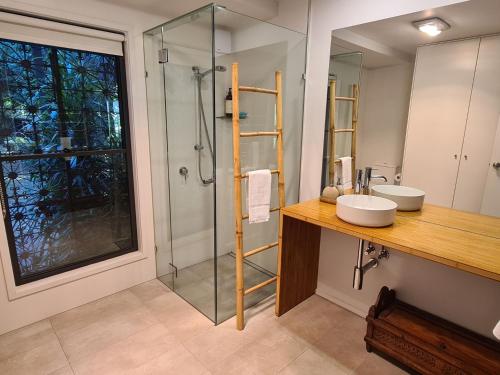 a bathroom with a sink and a glass shower at Rail Trail Cottage - Bright in Bright