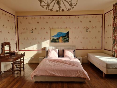 Domaine de Savignac في Chabanais: غرفة نوم بسرير ومكتب وثريا