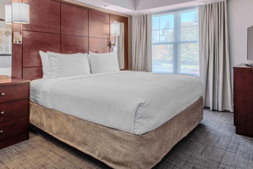a large bed in a hotel room with a large window at Residence Inn by Marriott Yonkers Westchester County in Yonkers