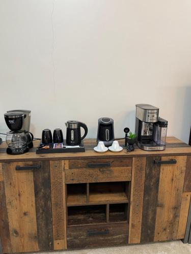 eine Holztheke mit zwei Kaffeemaschinen darauf in der Unterkunft رال هاوس in Al Wajh