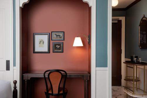 a hallway with a desk with a chair and a lamp at Hotel David Whitney, Autograph Collection in Detroit