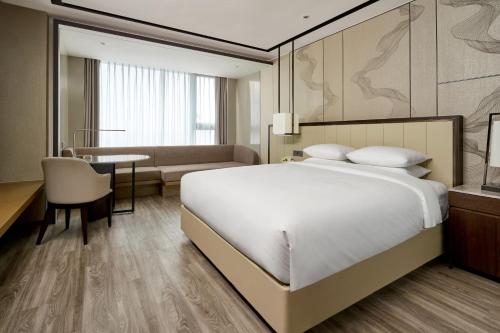 een slaapkamer met een bed, een bureau en een tafel bij Daegu Marriott Hotel in Daegu