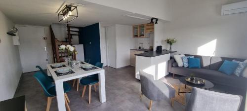 a living room and kitchen with a table and a couch at L'Ophelia Duplex Dernier étage balcon Centre climatisation in Sète
