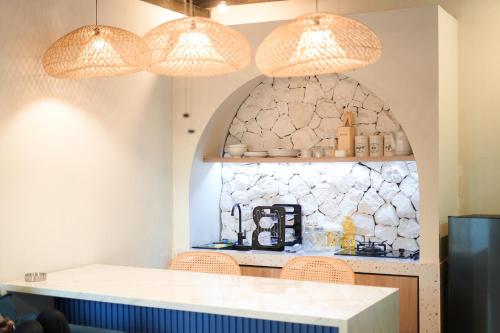 a kitchen with a counter and three lights at Ubu Villa Kinanthi - 1 BR in Yogyakarta in Bedoyo