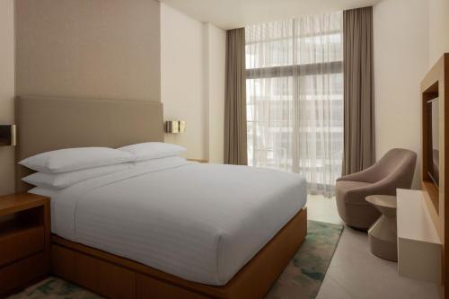 a bedroom with a white bed and a window at Marriott Marquis Dubai Creek in Dubai