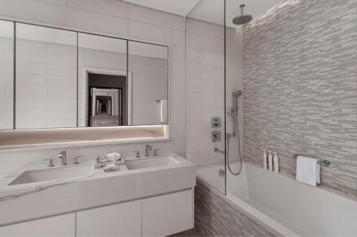 a white bathroom with a sink and a mirror at Marriott Marquis Dubai Creek in Dubai