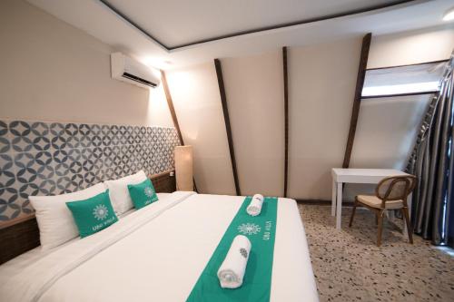 a bedroom with a bed and a table and a chair at Ubu Villa Kinanthi - 1 BR in Yogyakarta in Bedoyo