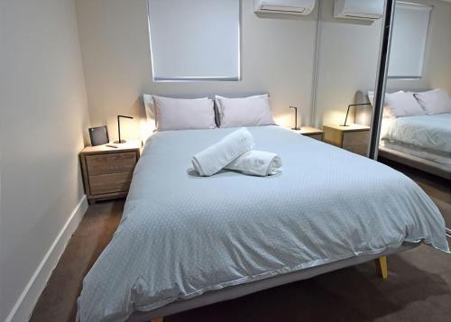 a bedroom with a large white bed with two pillows at Salt 5 Sorrento walk to beaches shops cafes and restaurants in Sorrento