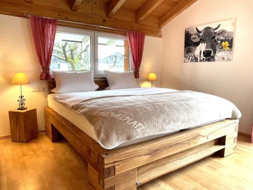 a large bed in a bedroom with two windows at Haus Leni in Fischen