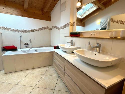 a bathroom with two sinks and a bath tub at Haus Leni in Fischen