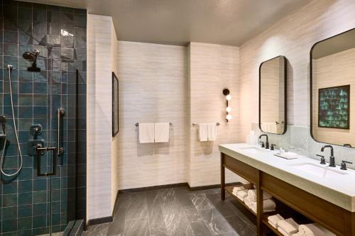 a bathroom with two sinks and a shower at Renaissance Phoenix Glendale Hotel & Spa in Glendale