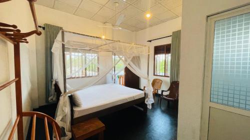 a bedroom with a canopy bed and a window at Villa Don Williams Weligama in Weligama