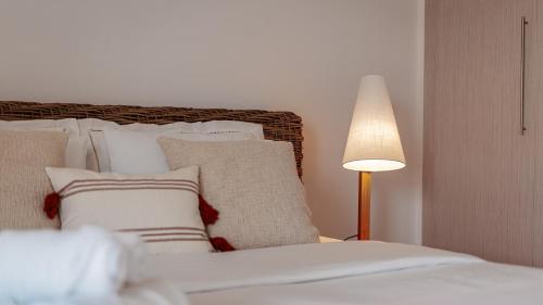 - une chambre avec un lit doté d'oreillers et d'une lampe dans l'établissement One Bedroom Apartment By Voyage, à Abu Dhabi