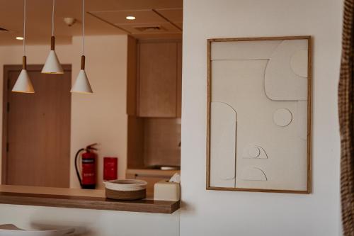 une cuisine avec une photo sur le mur dans l'établissement One Bedroom Apartment By Voyage, à Abu Dhabi