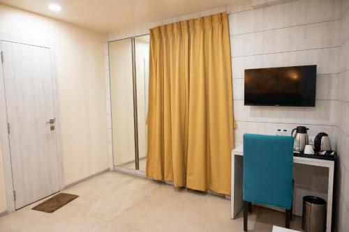 a room with a desk and a yellow curtain at The Opus Kolkata - A Boutique Hotel in Kolkata