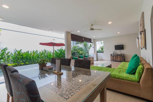 a living room with a couch and a table at The BALIem Villa in Jimbaran