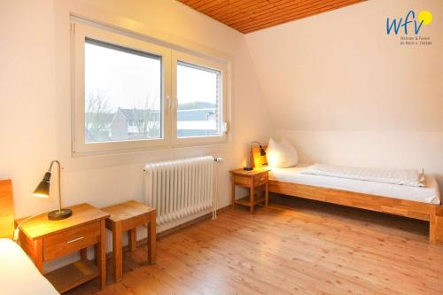 a small room with a bed and a window at Ferienhaus Seehundje Ferienwohnung 21 in Borkum