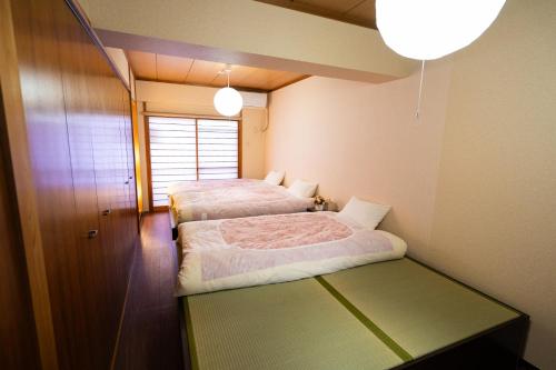 a bedroom with two beds and a table in it at N262walk 3 minutes to Osu shopping street stay 8 people in Aoichō