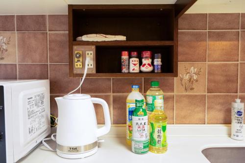 a kitchen counter with a microwave and bottles of condiments at N262walk 3 minutes to Osu shopping street stay 8 people in Aoichō