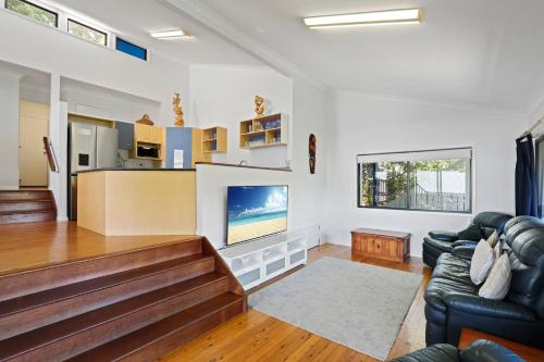 a living room with a couch and a tv at 19 Billa Street in Point Lookout