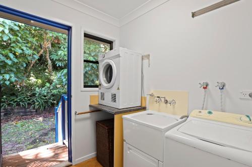 uma lavandaria com uma máquina de lavar roupa e um micro-ondas em 19 Billa Street em Point Lookout
