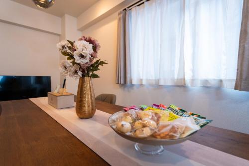 a bowl of food on a table with a vase of flowers at N262walk 3 minutes to Osu shopping street stay 8 people in Aoichō