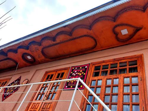 een gebouw met ramen en een balkon met een dak bij Istirohat guest house in Samarkand