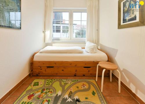 a small bedroom with a bed and a window at Luv und Lee Ferienwohnung Pilsum in Juist
