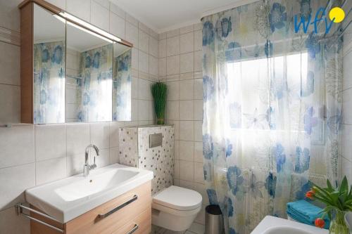 a bathroom with a sink and a toilet and a shower curtain at Haus Bode Ferienwohnung Bode in Borkum