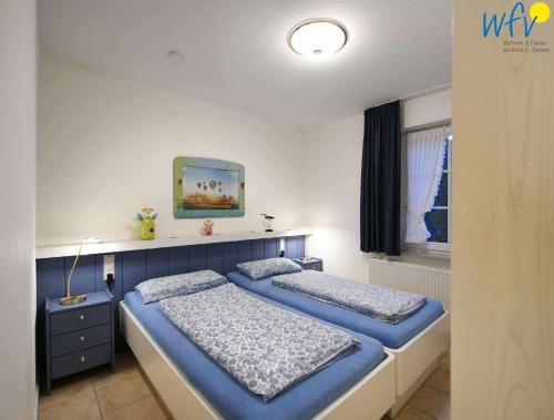 a bedroom with two beds and a window at Luv und Lee Ferienwohnung Westerhever in Juist