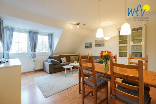 een keuken en een woonkamer met een tafel en stoelen bij Juist Zauber - Haus 3 Ferienwohnung Ockjes Stuuv in Juist