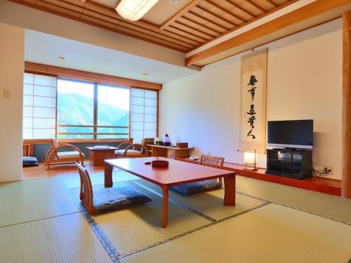 a living room with a table and a television at Hotel Miki in Gero
