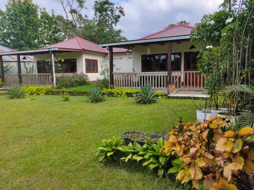 a house with a green yard in front of it at Ilasan cottage. in Tomohon