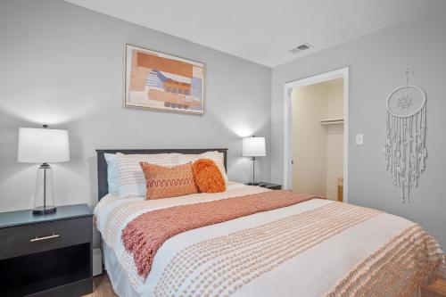 a bedroom with a large bed with orange pillows at Downtown Med District: Stylish & Modern 2BD, 1BA Capital City Escape! in Springfield