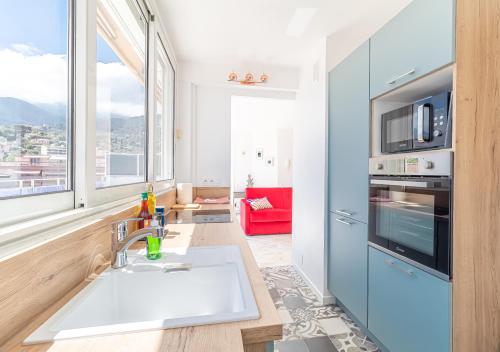 une cuisine avec un évier et une grande fenêtre dans l'établissement Superb Rooftop Roquebrune Parking, à Roquebrune-Cap-Martin