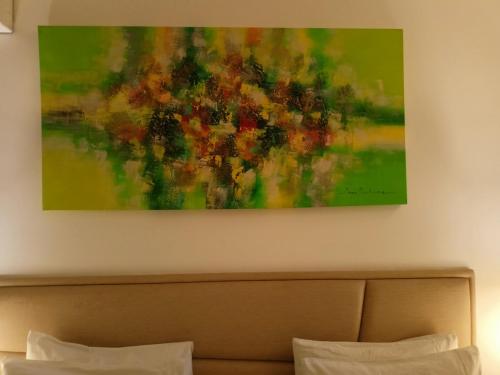 a painting hanging above a bed in a hotel room at Lime Hotel Boracay in Boracay