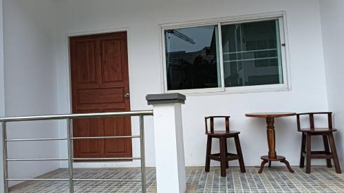 a porch with a table and two chairs and a window at Norrarat Place นรรัตน์ เพลส in Chiang Rai