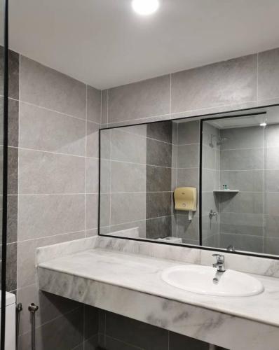 a bathroom with a sink and a large mirror at Coral Bay Resort in Pangkor