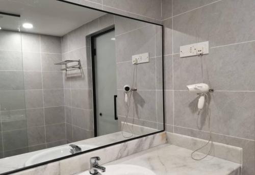 a bathroom with a shower and a sink and a mirror at Coral Bay Resort in Pangkor