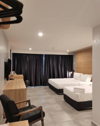 a hotel room with two beds and a desk at Coral Bay Resort in Pangkor