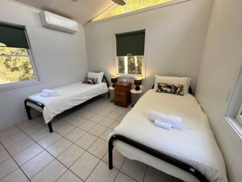1 dormitorio con 2 camas y ventana en Gindabara Coochiemudlo Island, en Coochiemudlo