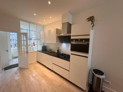 een keuken met witte kasten en een fornuis met oven bij Tulip House Luxury Apartment - Top Location - Rijksmuseum - Leidseplein AMSTERDAM Central 120 m2 ALL Private with kitchen in Amsterdam