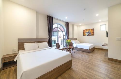 a hotel room with two beds and a table at TALA Dalat Hotel in Da Lat